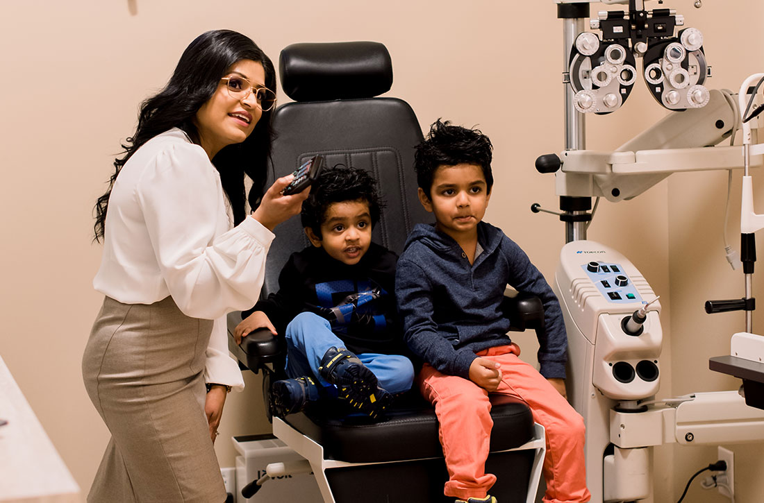 Dr. Krishna Khatri with two young boys eye exam